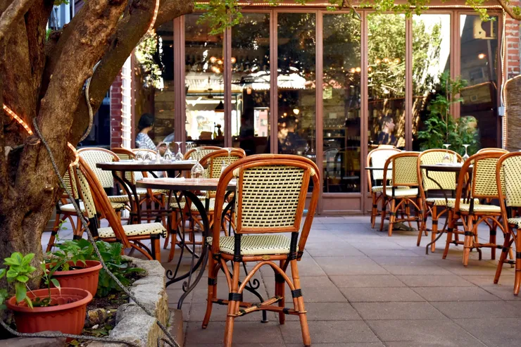 A restaurant with tables and chairs outside of it