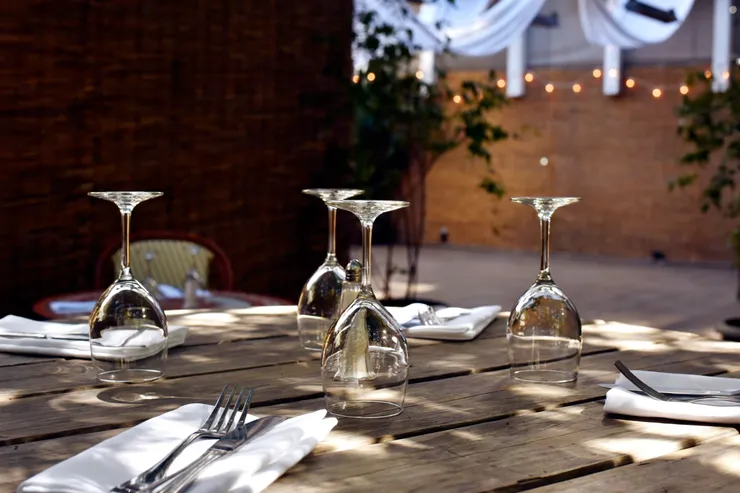 A table with wine glasses and silverware on it.