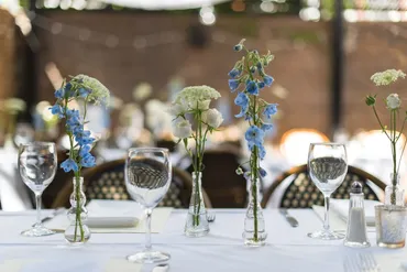 A table with four vases of flowers on it