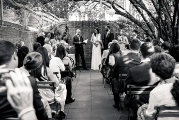 A black and white photo of people in an outdoor ceremony.