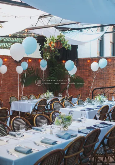 A table set up for an outdoor party with balloons.