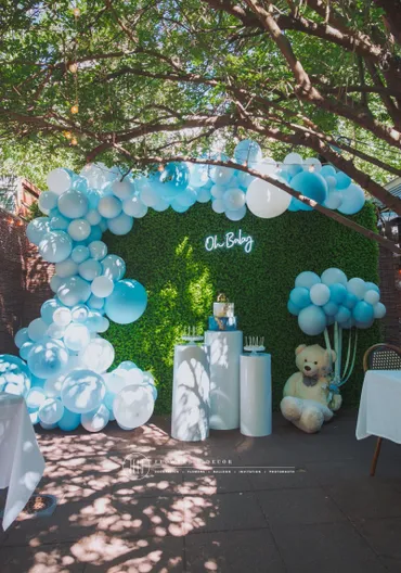 A baby shower with balloons and greenery