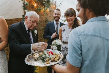 A man holding a tray of food with people around him.
