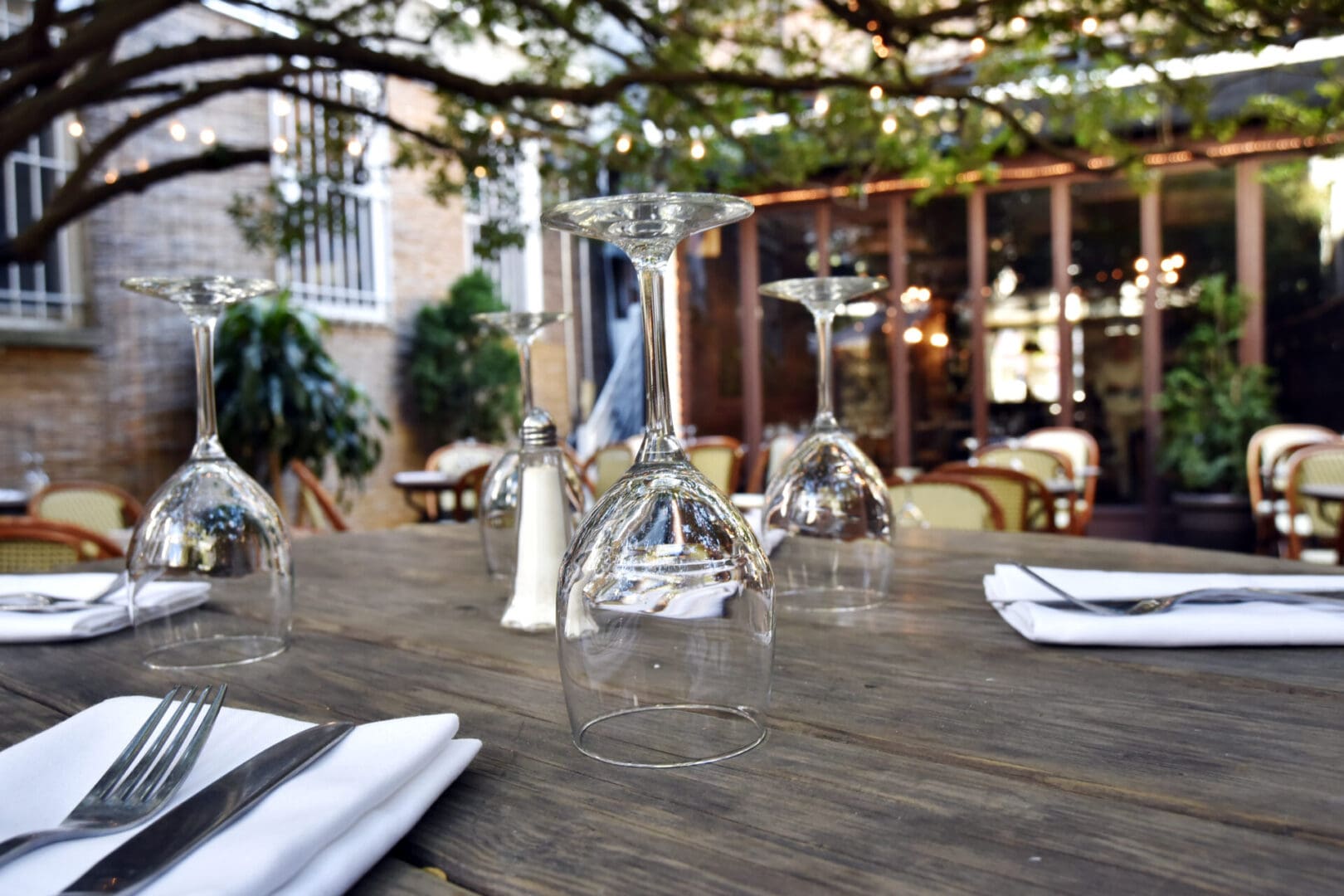 A table with wine glasses and napkins on it.