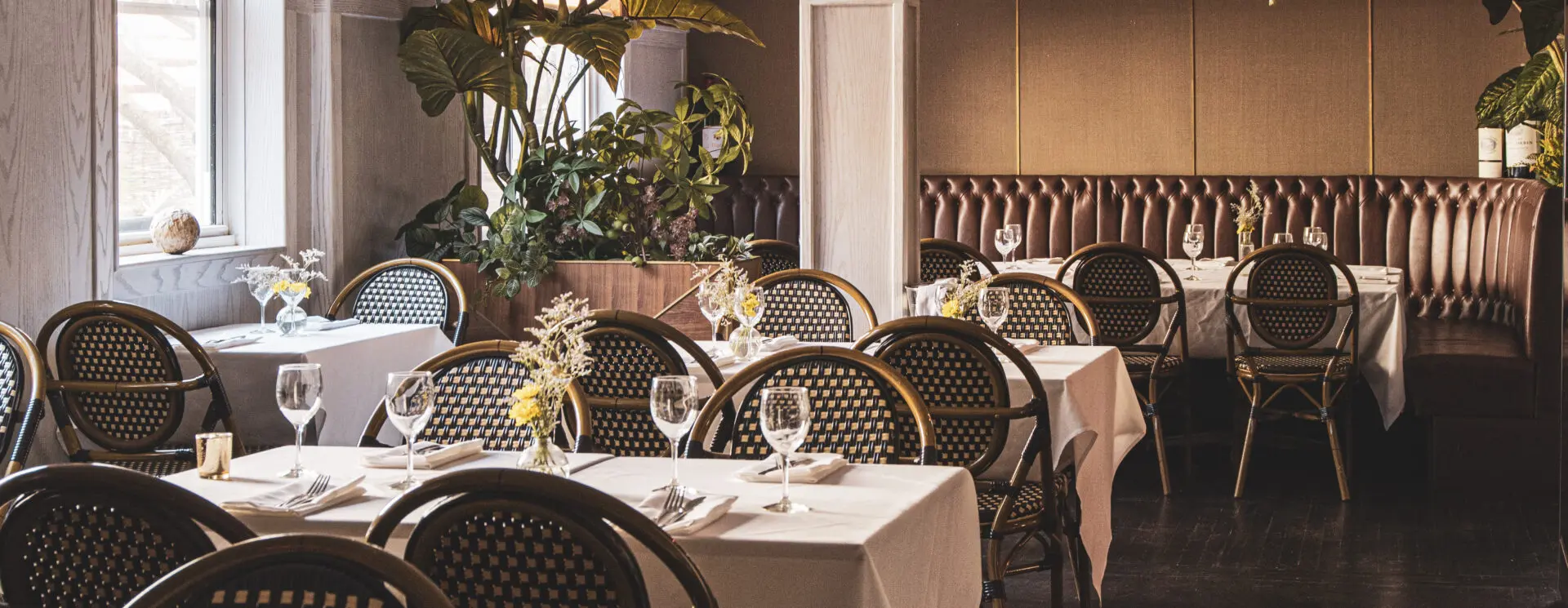 A restaurant with tables and chairs set up for dinner.