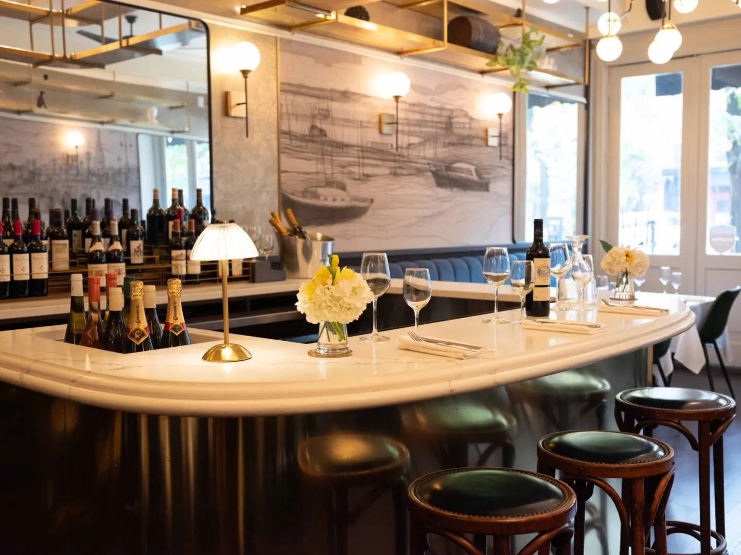 Curved bar with wine and barstools.