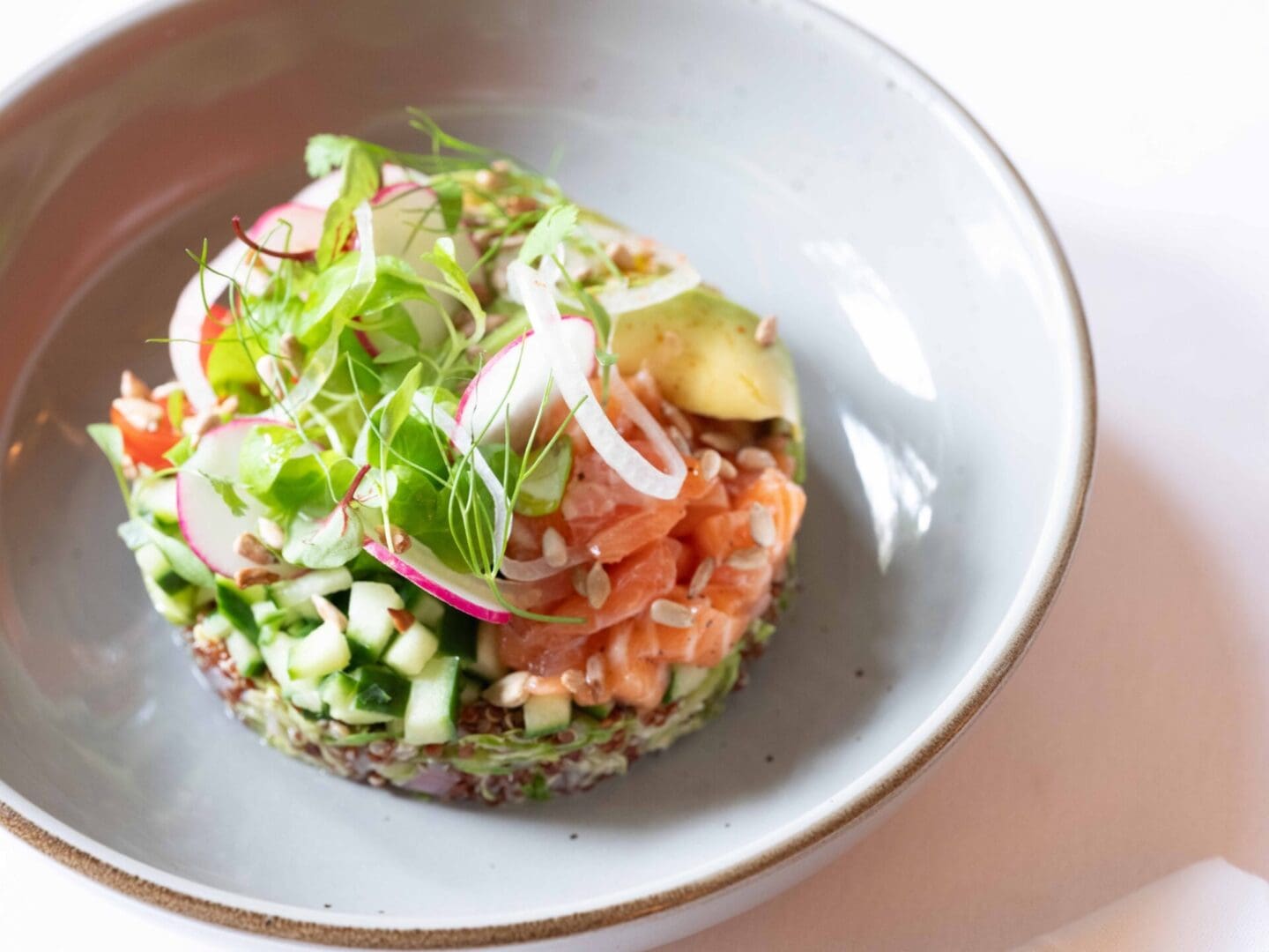 Salmon and cucumber salad with avocado and radish.