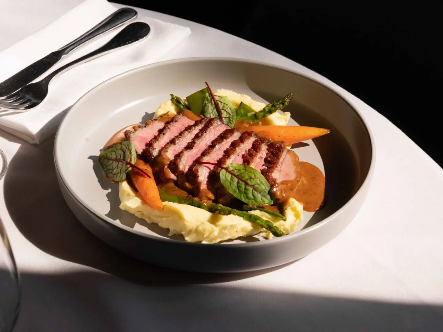 Seared duck breast with mashed potatoes and gravy.