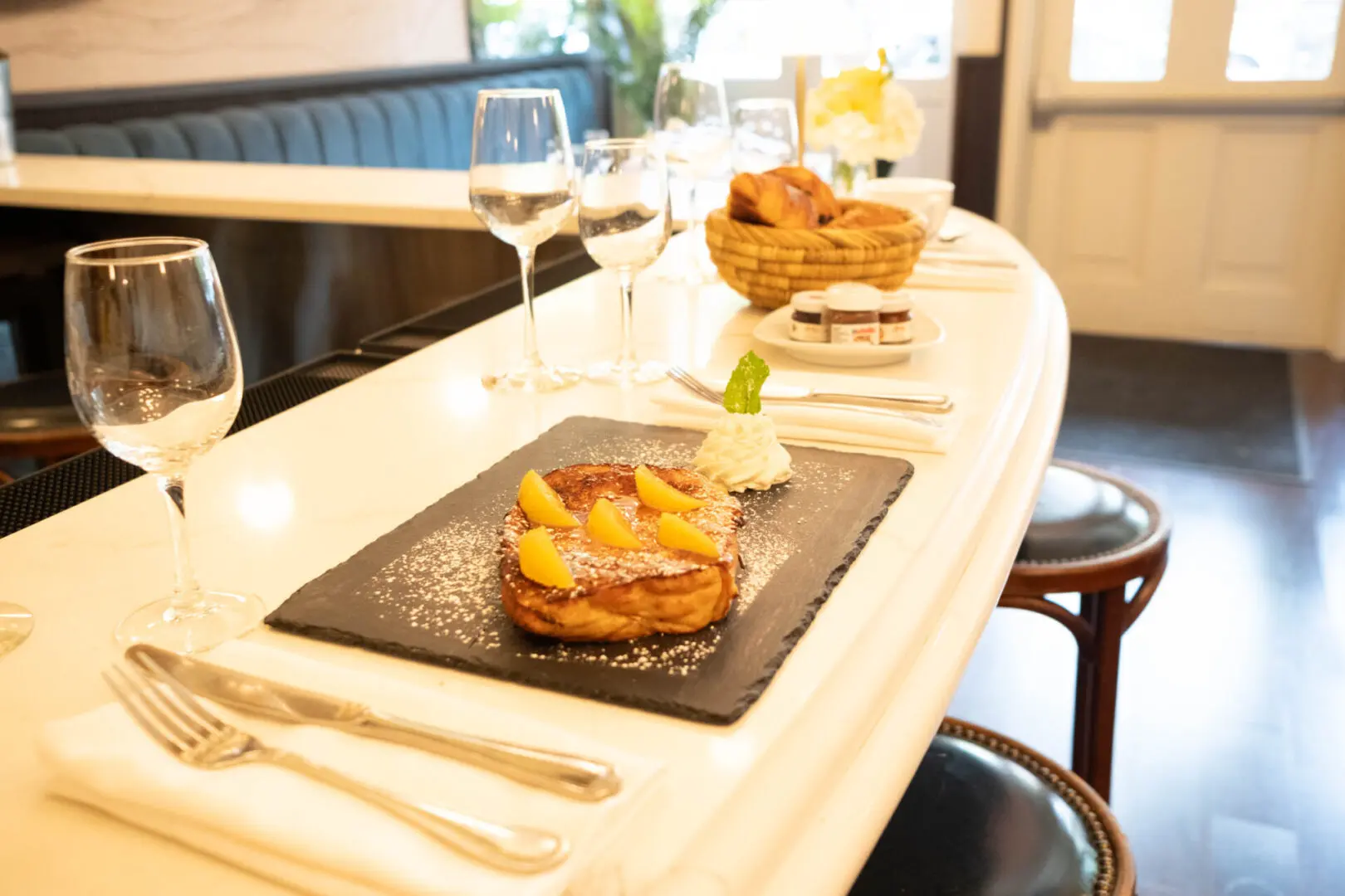 French toast with orange slices on a slate plate.